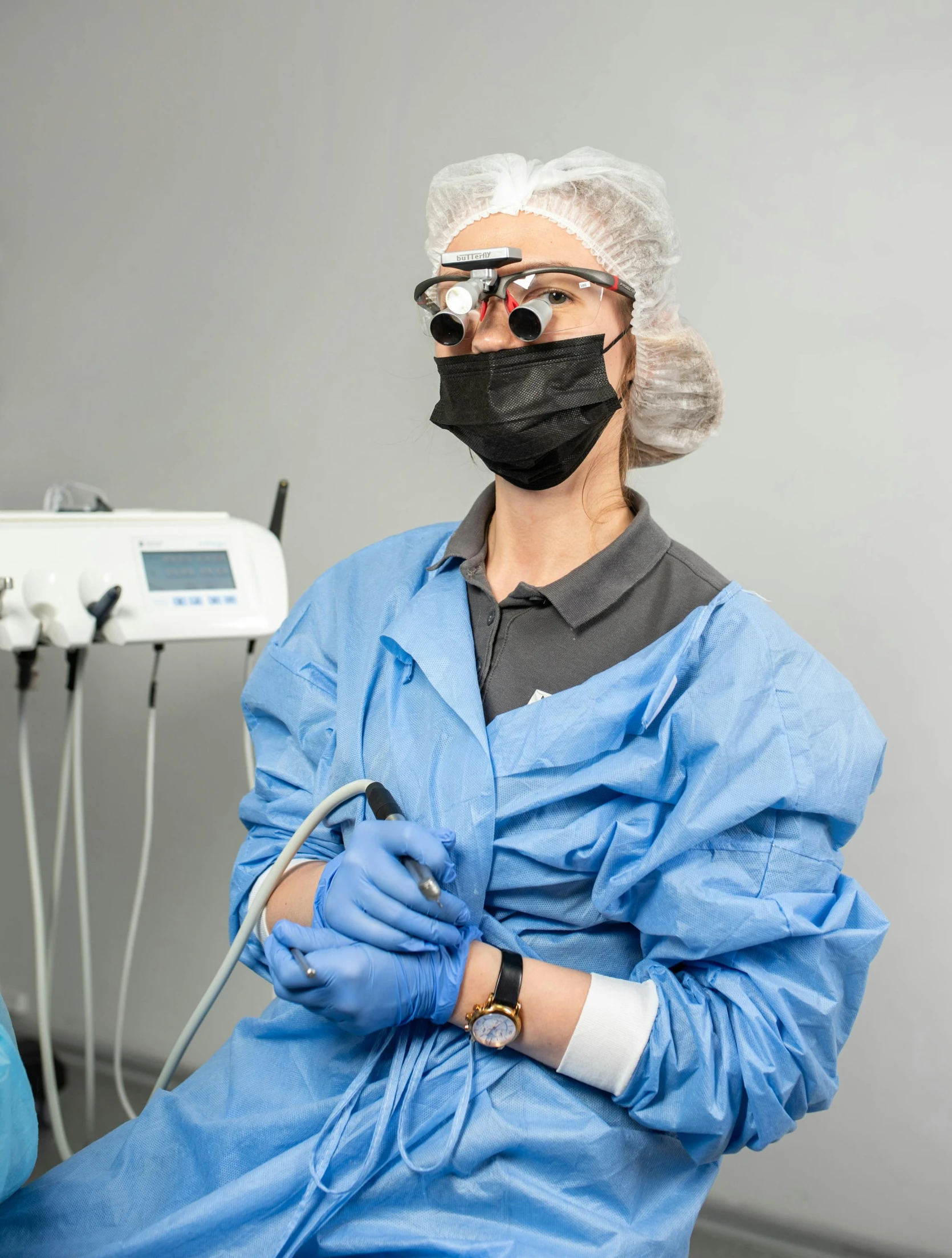 a man sitting in a chair with a mask on, happening, uniform teeth, lasers, gray, black