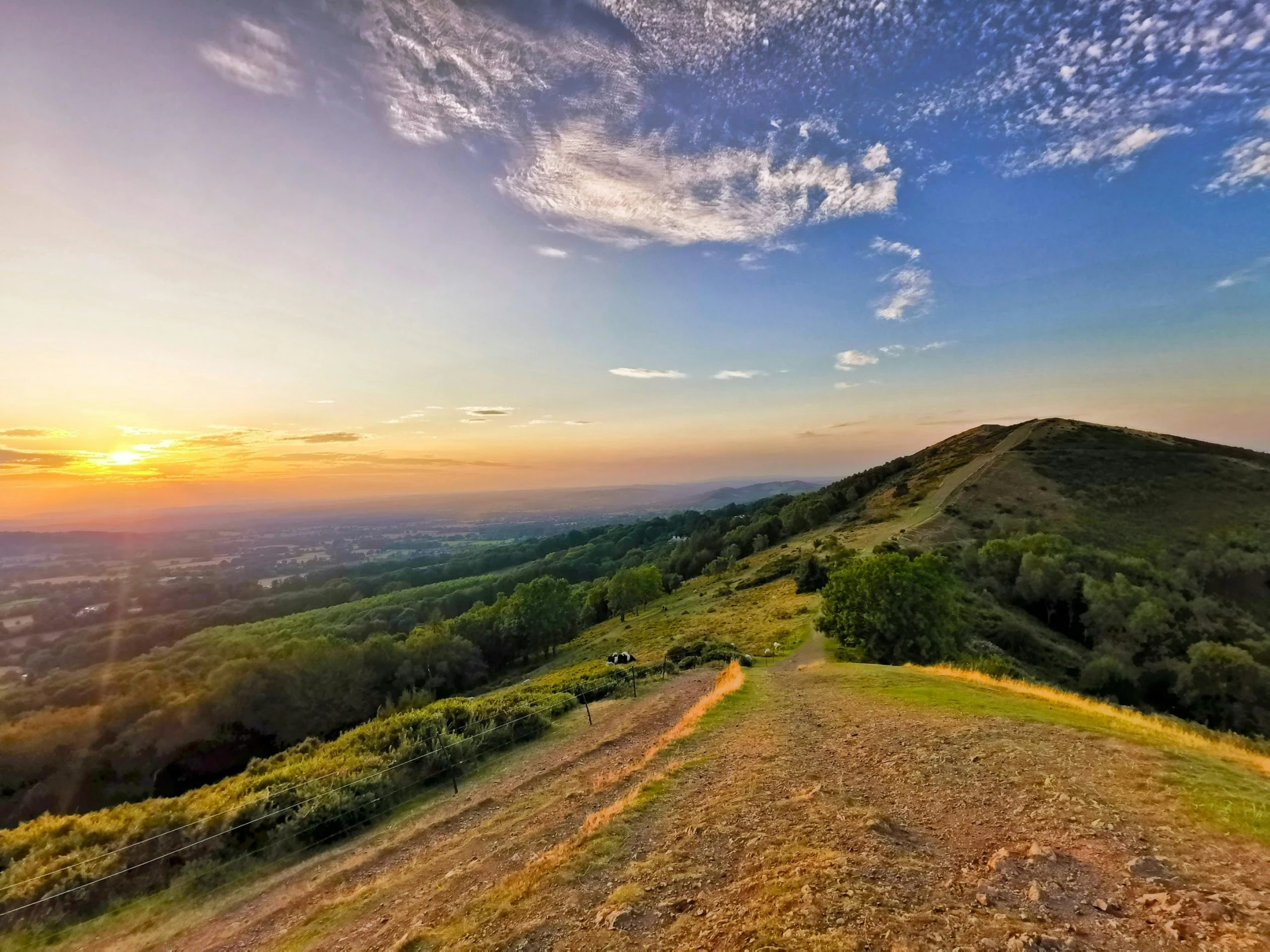 a view from the top of a hill at sunset, by Julian Allen, pexels contest winner, instagram post, green hills, multiple stories