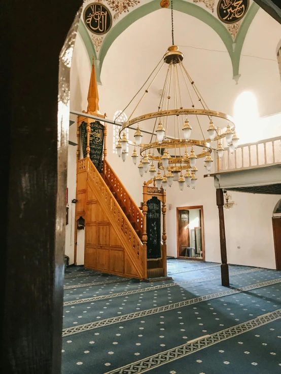 the inside of a building with a chandelier hanging from the ceiling, inspired by Abdullah Gërguri, trending on unsplash, hurufiyya, full-length view, facing front, wood and gold details, muslim