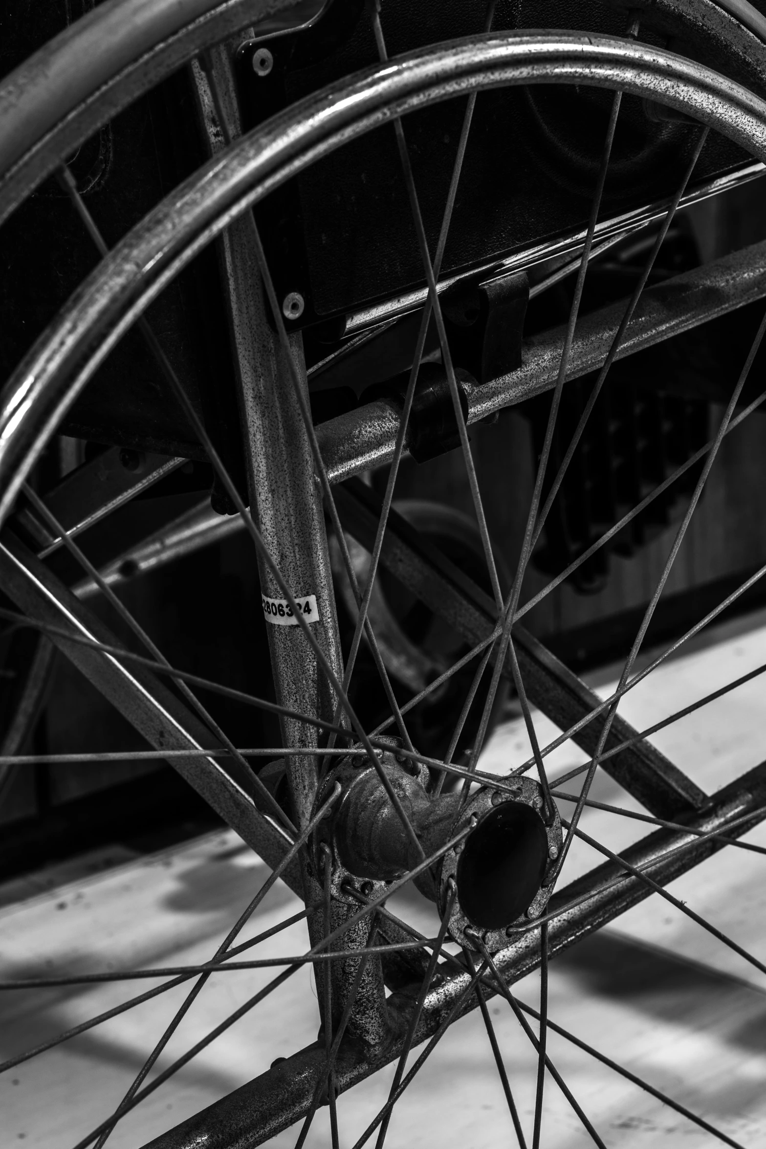 a black and white photo of a bicycle wheel, broken wheelchair, aerodynamic frame, profile image, rusty components