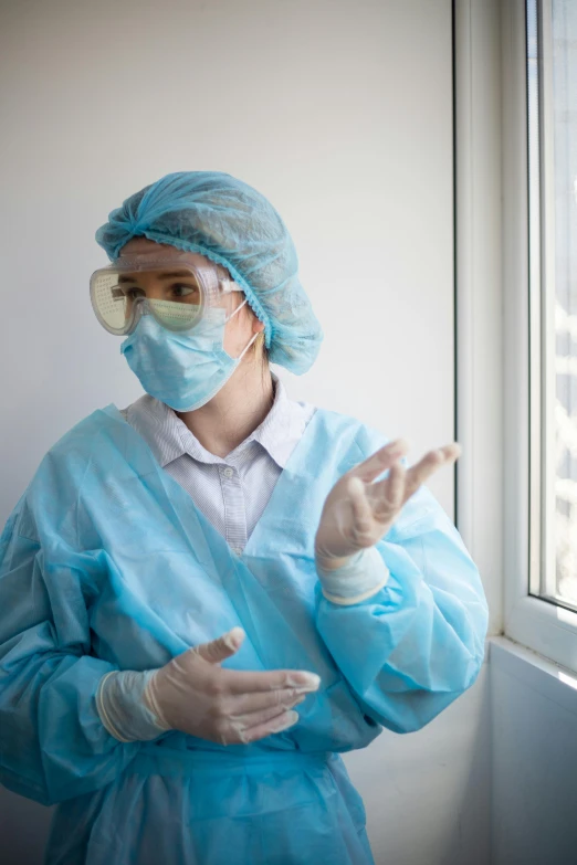 a woman in a hospital gown standing by a window, shutterstock, happening, staff wearing hazmat suits, convincing, dasha taran, goggles