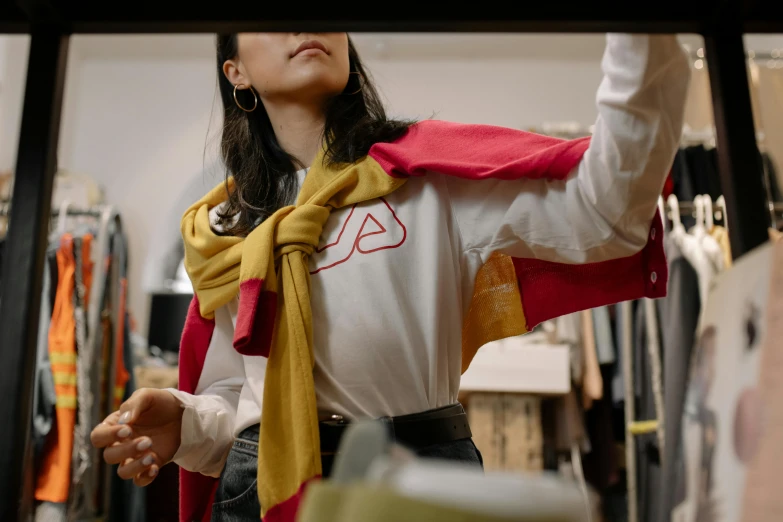 a woman in a white shirt and a red and yellow scarf, trending on unsplash, the store, wearing correct era clothes, touching her clothes, zelda