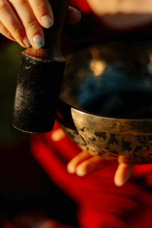 a close up of a person holding a bowl, holding a bell, light and dark, liquid hands and feet spinning, samsara