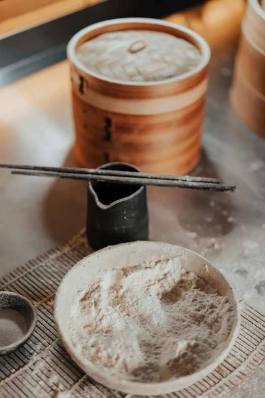 a close up of a plate of food on a table, inspired by Tani Bunchō, trending on unsplash, process art, flour dust, wood cups, tools, production photo