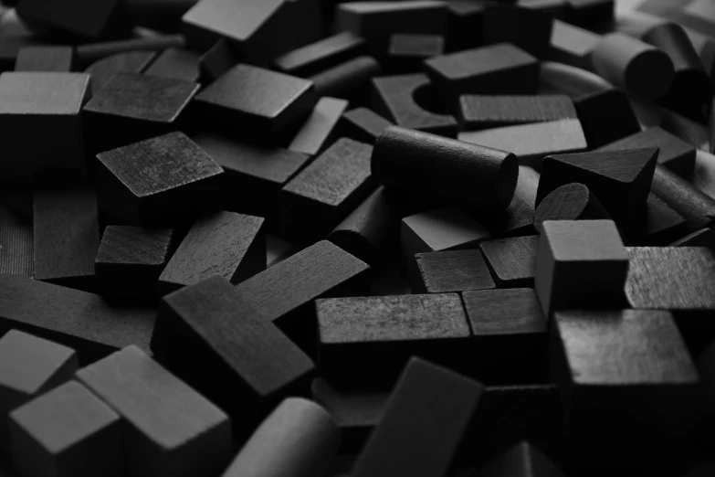 a pile of wooden blocks sitting on top of a table, by Emma Andijewska, unsplash, conceptual art, vantablack chiaroscuro, square shapes, background image, black