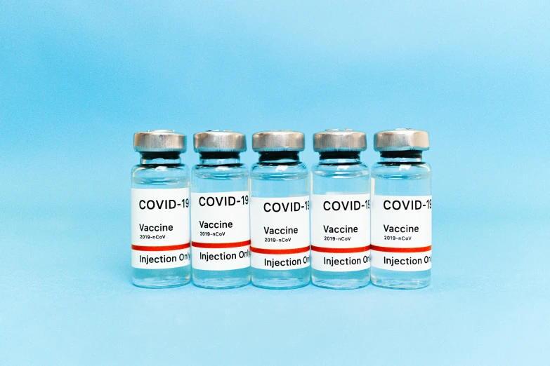 three vials of covidd vaccine on a blue background, a picture, by Gavin Hamilton, shutterstock, 6 pack, label, set against a white background, profile pic