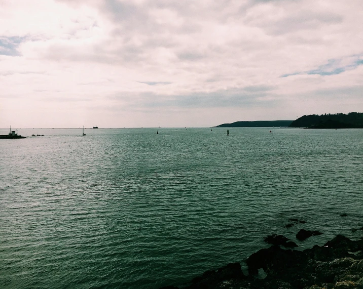 a body of water with boats in the distance, by Rachel Reckitt, unsplash, happening, slight overcast weather, green sea, snapchat photo, bay area