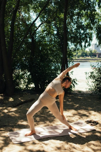 a woman doing a yoga pose on a yoga mat, a picture, by Sebastian Vrancx, unsplash, arabesque, in a park, soft shade, at the waterside, cardboard