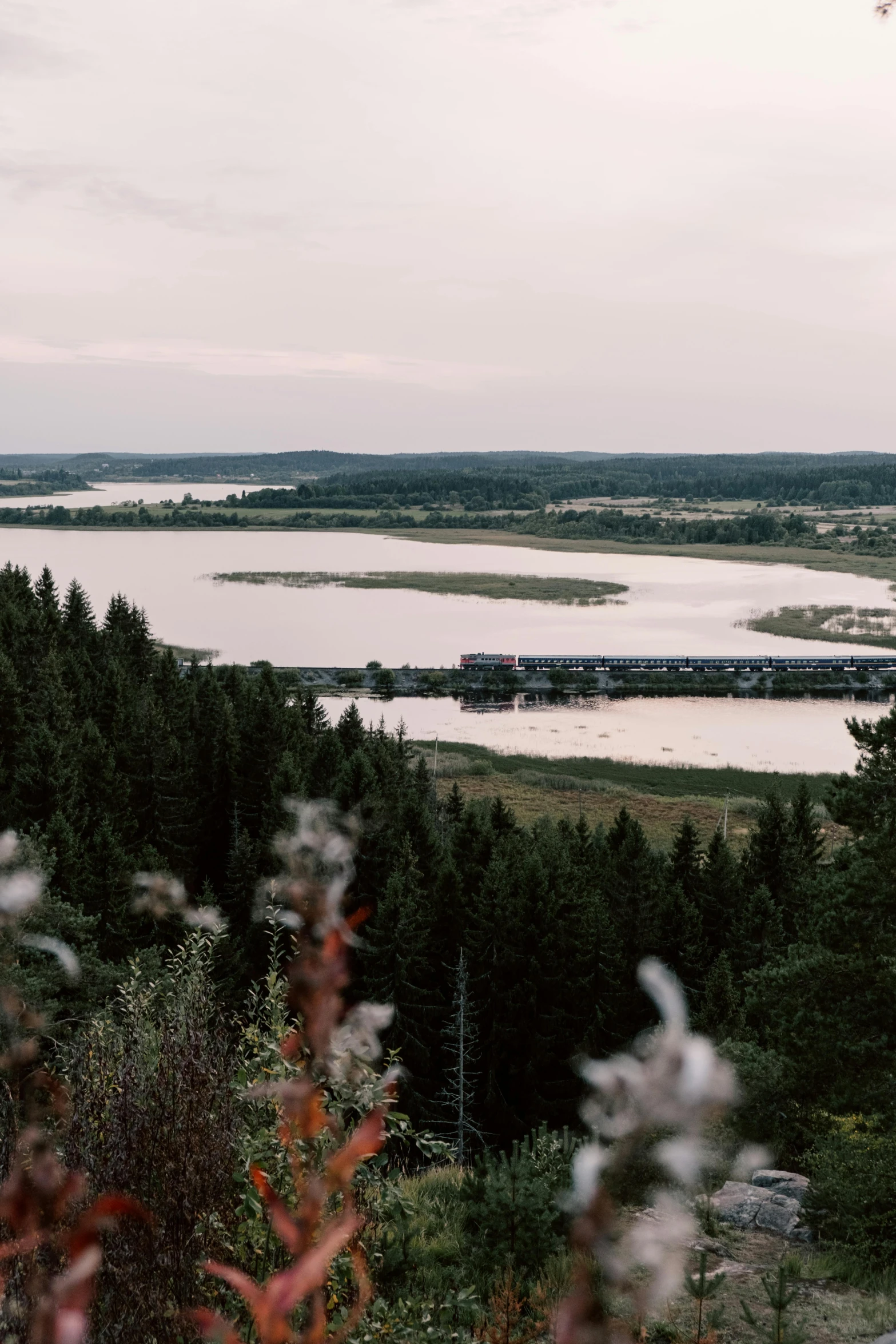 a man flying a kite on top of a lush green hillside, by Tobias Stimmer, unsplash, hurufiyya, wide river and lake, northern finland, view over city, a 35mm photo