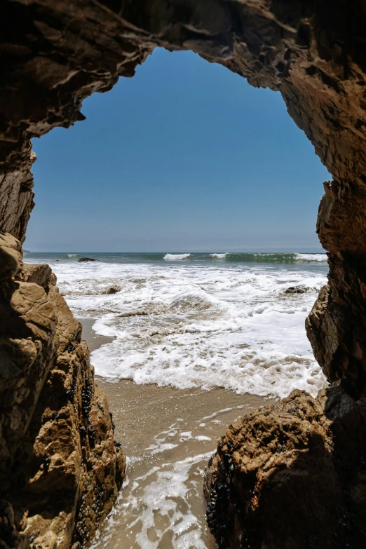 a view of the ocean from inside a cave, by Kristin Nelson, slide show, malibu canyon, archs and walls, rock and sand around