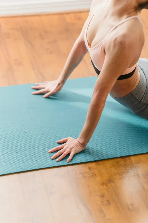 a woman doing a yoga pose on a yoga mat, thumbnail, teal cloth, upper body image, no - text no - logo
