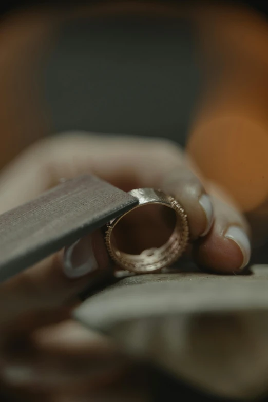 a person cutting a piece of paper with a knife, an engraving, inspired by Pieter de Ring, trending on unsplash, chaumet style, leica 8k still from an a24 film, gold and luxury materials, carving