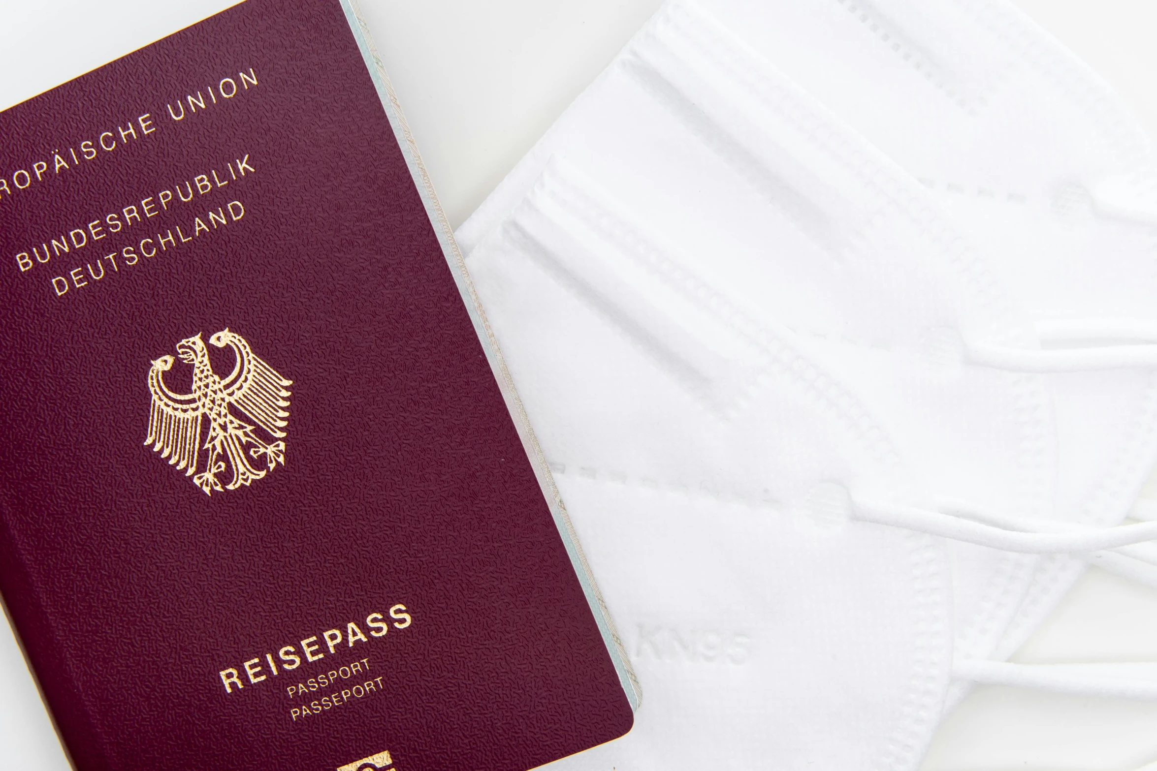 a passport and a face mask on a table, by Kristian Zahrtmann, white soft leather model, detailed white, auslese, healthcare