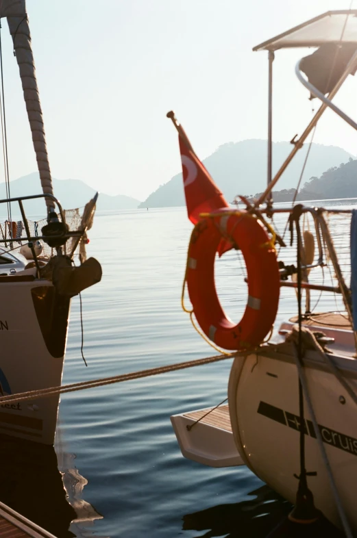 a couple of boats sitting on top of a body of water, happening, turkey, film photograph, sun drenched, sail