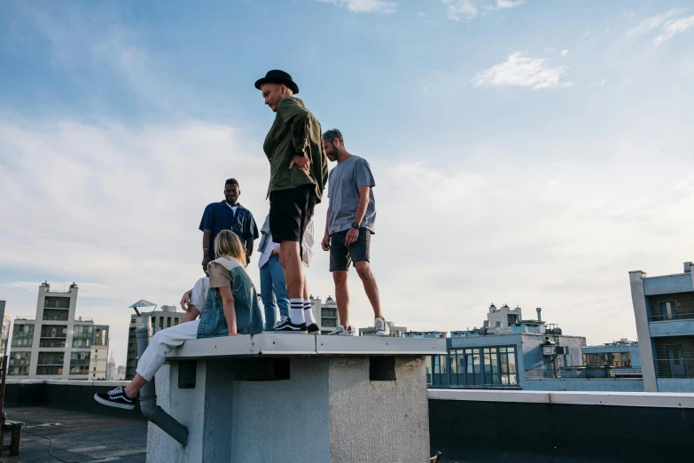 a group of people standing on top of a building, a photo, by Niko Henrichon, looking to the side off camera, summertime, sitting on top a table, guy billout