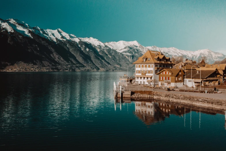 a large body of water with mountains in the background, by Matthias Weischer, pexels contest winner, visual art, swiss architecture, quaint, avatar image, 2 0 0 0's photo