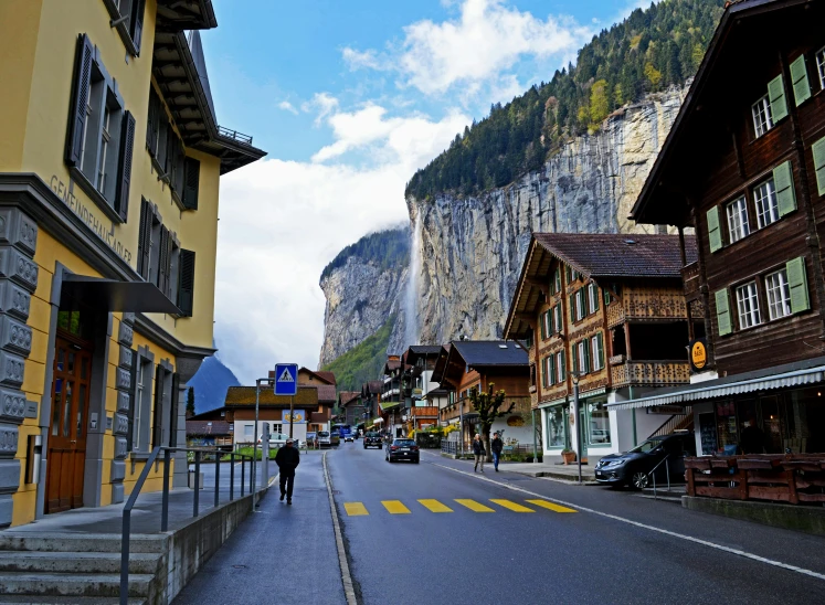 a person walking down a street with a mountain in the background, by Julia Pishtar, pexels contest winner, renaissance, lauterbrunnen valley, square, slide show, high rises