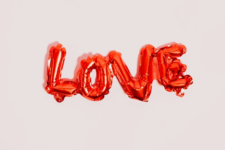 a red balloon with the word love written on it, pexels, foil effect, 🦩🪐🐞👩🏻🦳, essence, miranda meeks