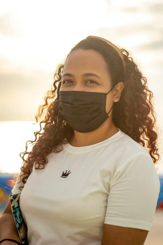 a woman wearing a face mask on the beach, renaissance, black main color, samoan features, medium - shot, promotional photo