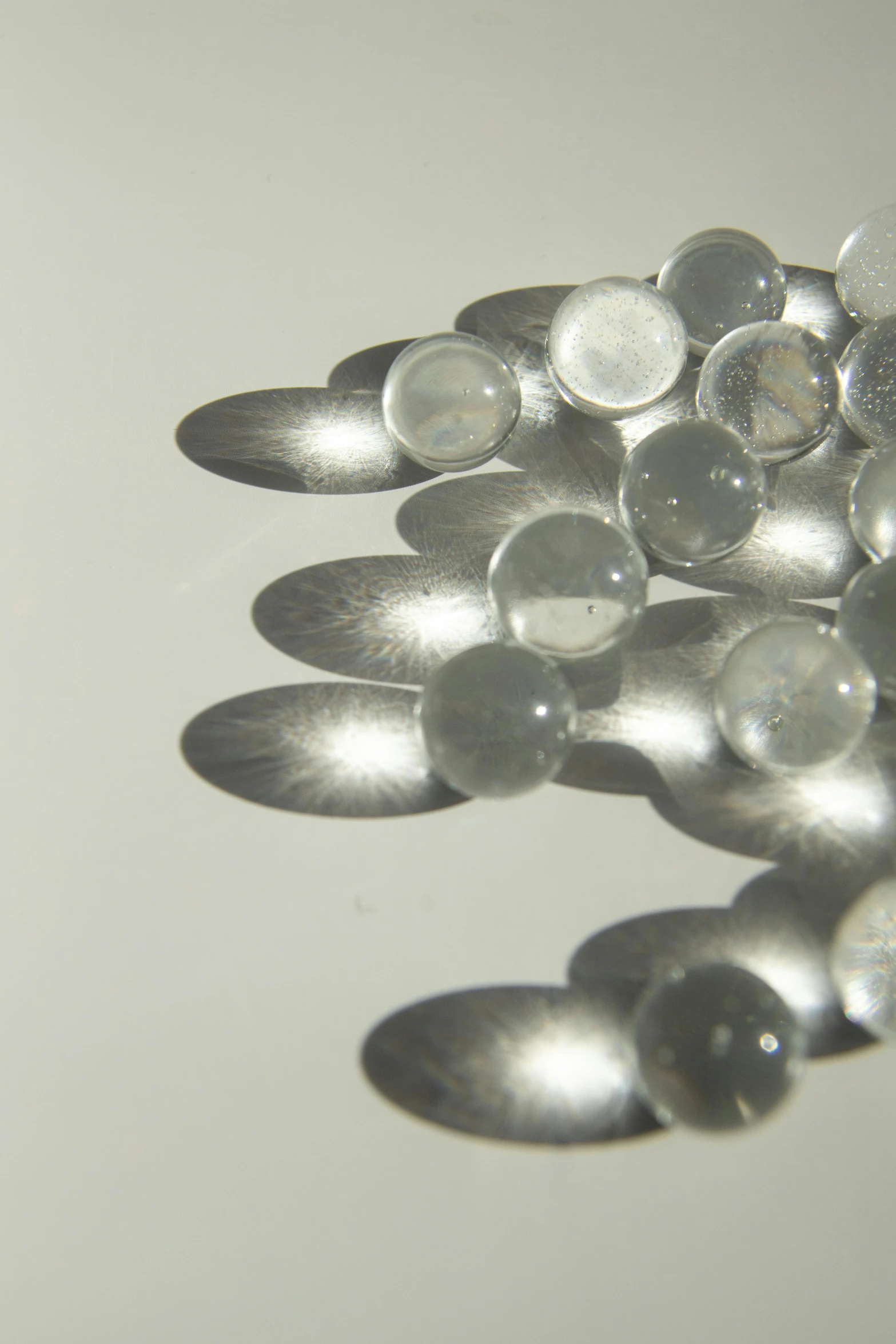 a bunch of spoons sitting on top of a table, a macro photograph, inspired by Vija Celmins, translucent orbs, detail shot, moonstone, made of liquid metal