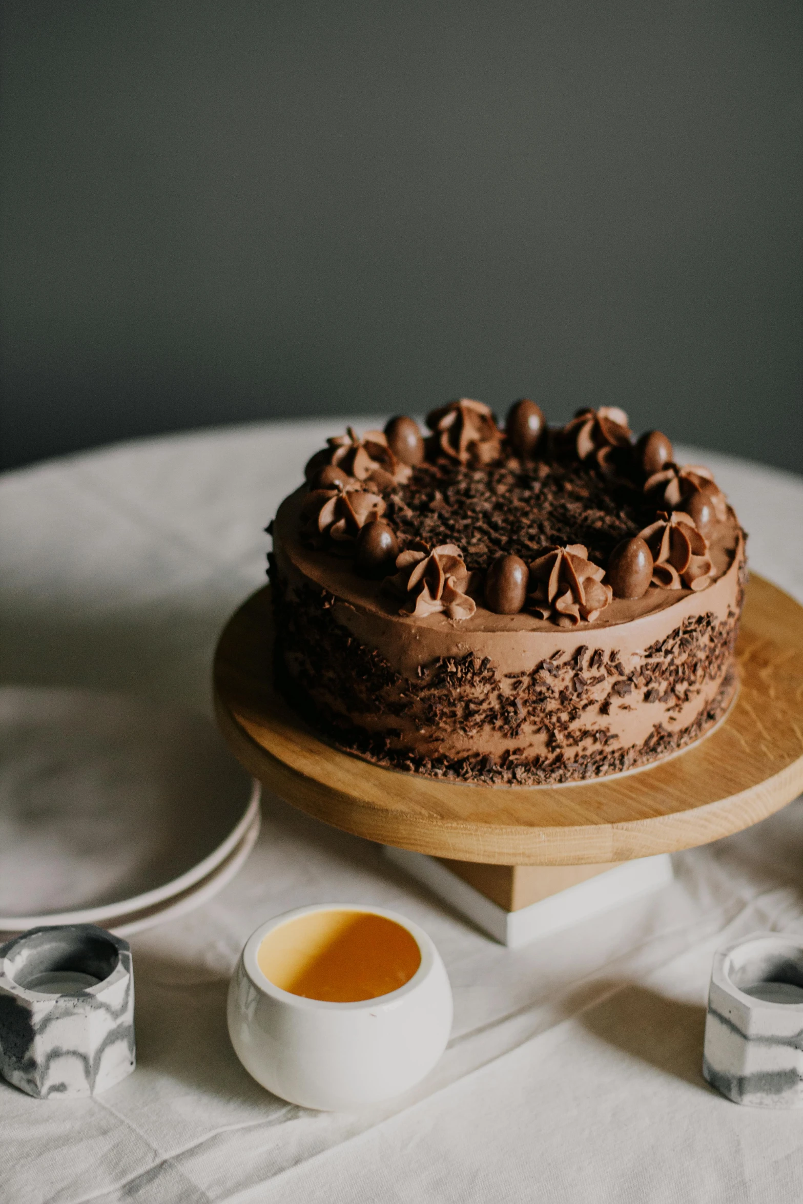 a chocolate cake sitting on top of a table, a still life, by Winona Nelson, pexels contest winner, celebration of coffee products, on grey background, celebrating a birthday, on a wooden tray