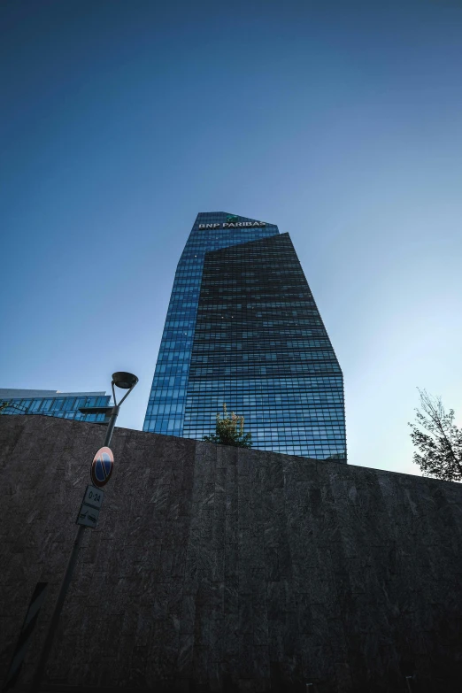 a man riding a skateboard on top of a cement wall, an album cover, by Carlo Martini, unsplash, surrealism, modern glass building, madrid, brutalist office buildings, seen from a distance