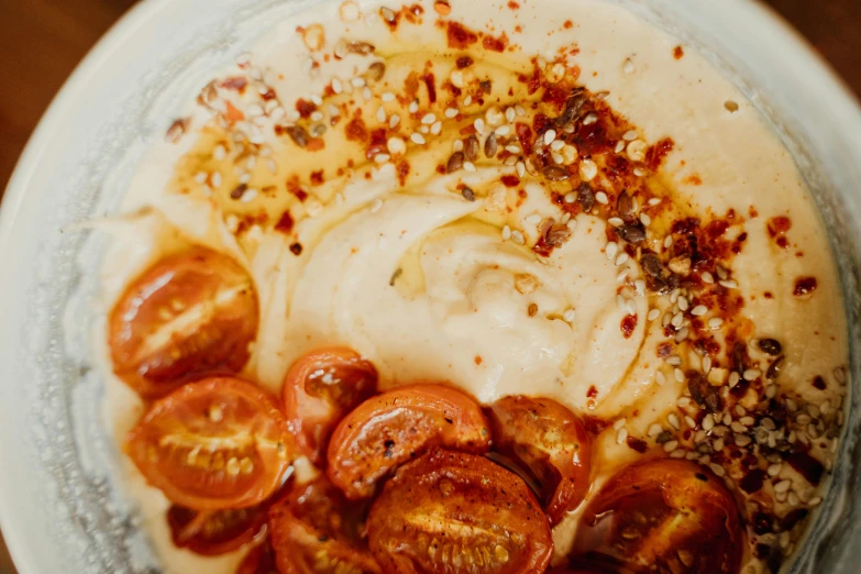 a close up of a plate of food on a table, humus, tomato splatter, manuka, bowl