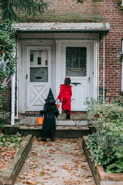 two children dressed up as witches in front of a house, pexels, about to enter doorframe, gif, square, il