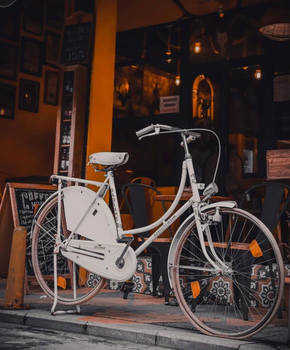 a white bicycle parked in front of a restaurant, profile image, during the night