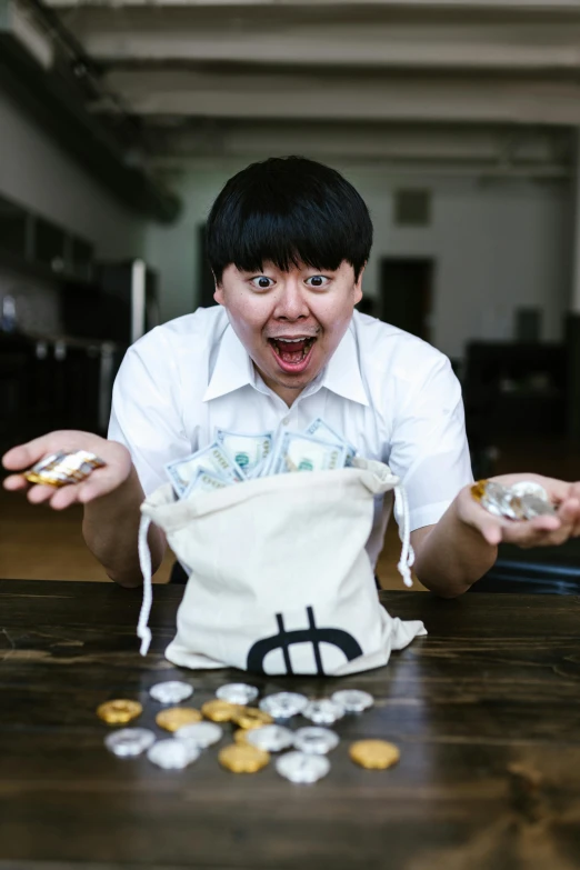 a man sitting at a table with coins in front of him, an album cover, pexels contest winner, mingei, bags of money, leslie zhang, excited, jontron