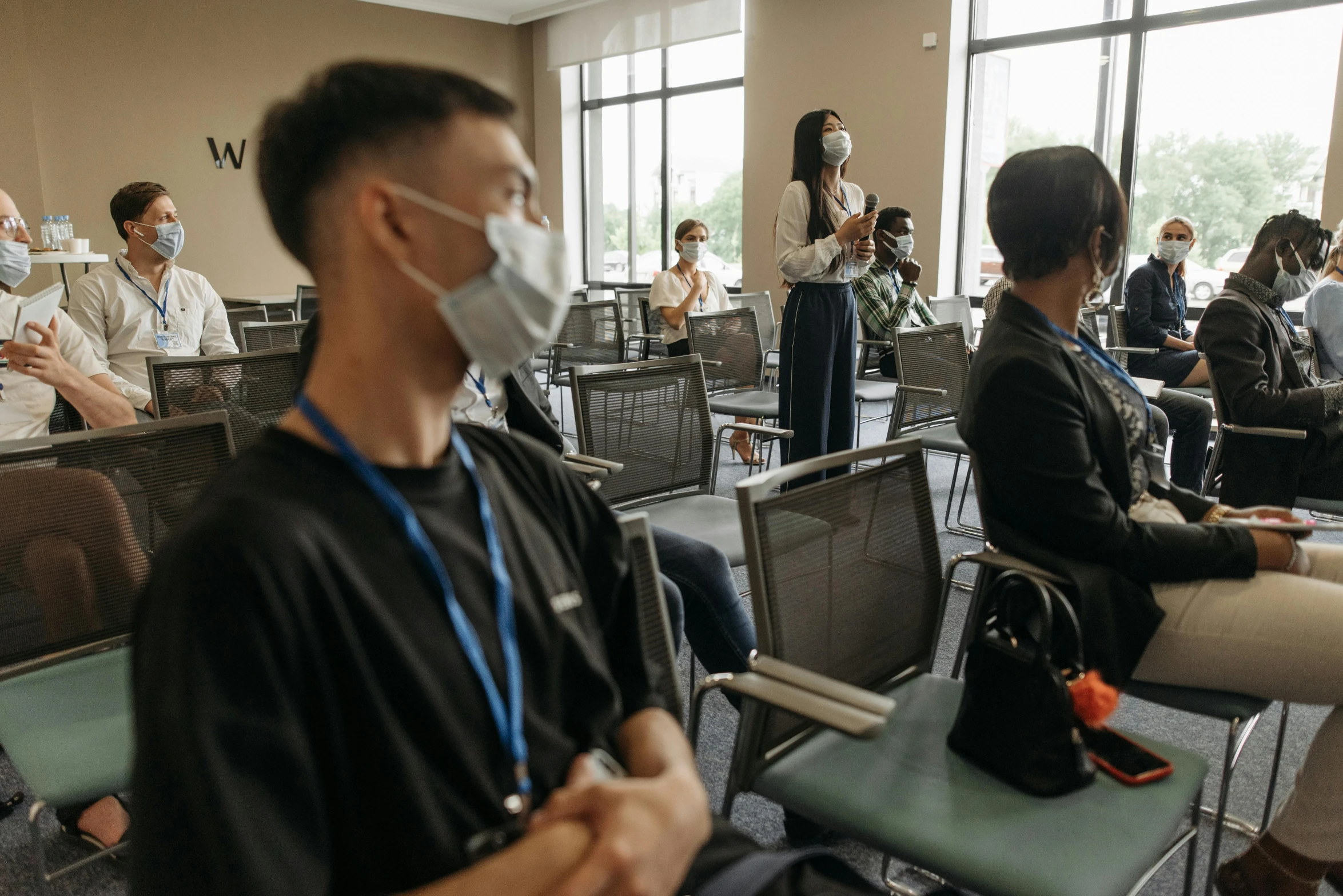 a group of people sitting in chairs in a room, wearing facemask, standing in class, baotou china, anton fadeev 8 k