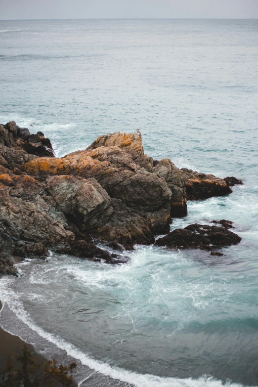 a large body of water next to a rocky shore, a picture, inspired by Elsa Bleda, pexels contest winner, wellington, today\'s featured photograph 4k, single figure, tumultuous sea