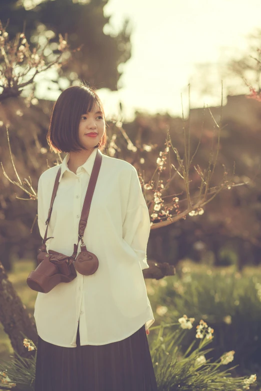 a woman standing in front of a tree, by Tan Ting-pho, unsplash, happening, hasselblad film bokeh, wearing a linen shirt, promo image, spring evening