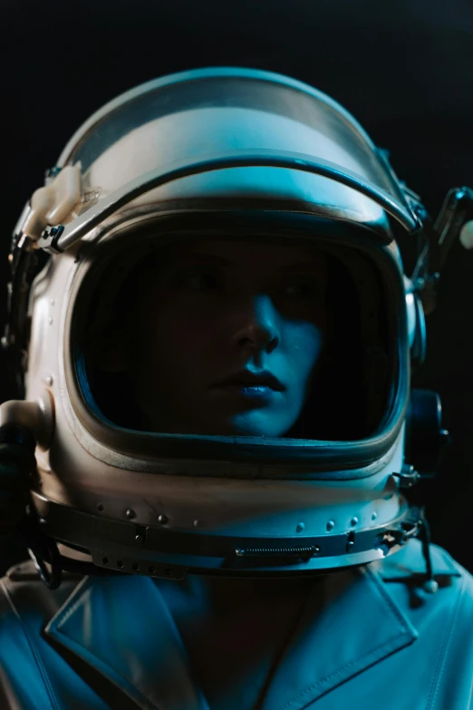 a close up of a person in a space suit, an album cover, pexels contest winner, movie still 8 k, wearing her helmet, blue, ww2 space tech