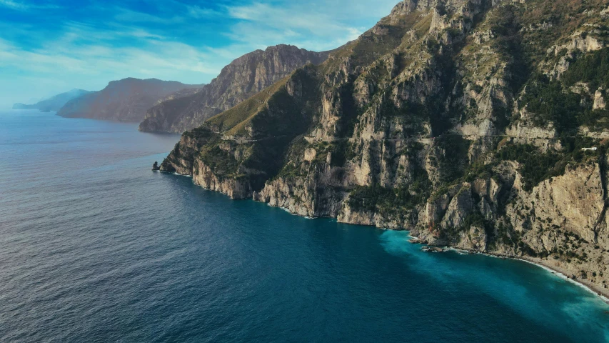 a large body of water next to a cliff, by Simon Marmion, pexels contest winner, les nabis, vouge italy, real engine 5 cinematic, slim aarons, 8k cinematic