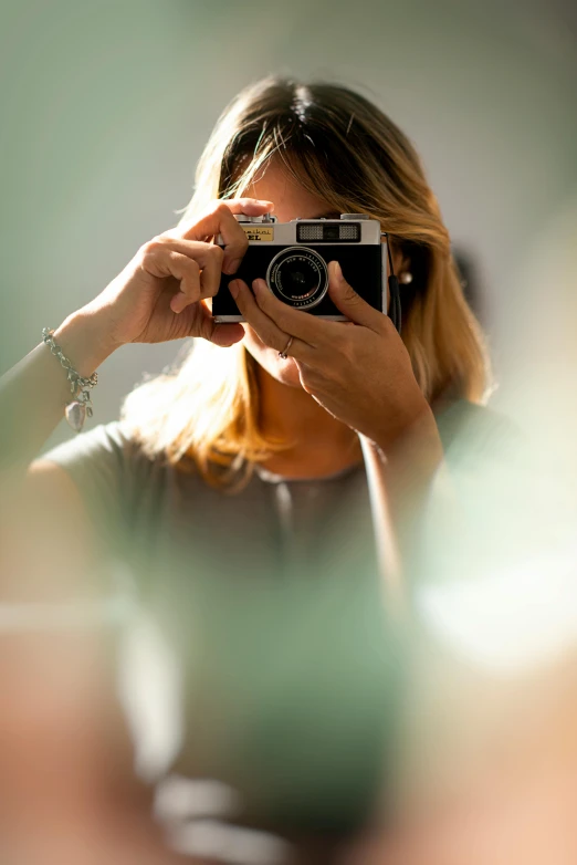 a woman taking a picture of herself with a camera, inspired by Elsa Bleda, unsplash, photorealism, medium format color photography, a blond, low detail, f/8.0