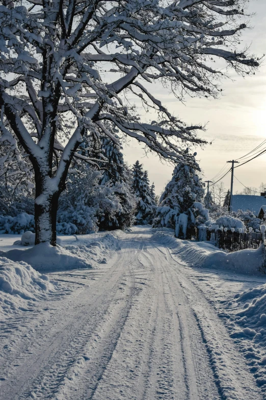 a person riding a snowboard down a snow covered road, a photo, inspired by Edward Willis Redfield, quaint village, today\'s featured photograph 4k, a quaint, in 4k