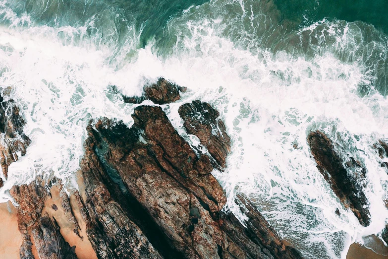 a person standing on top of a rock next to the ocean, pexels contest winner, process art, turbulent water, flatlay, thumbnail, taken from a plane