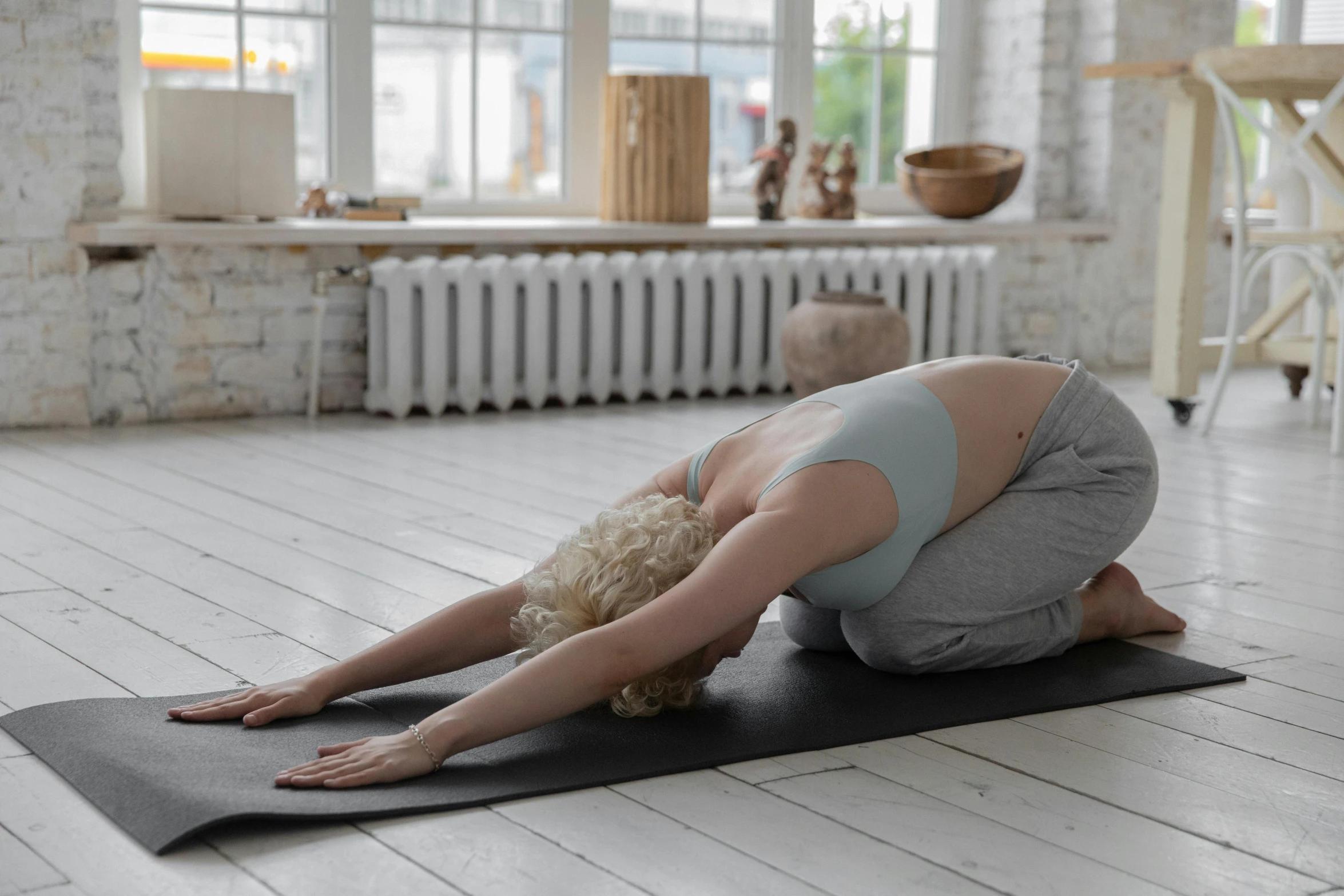 a woman doing a yoga pose on a yoga mat, a picture, by Helen Stevenson, trending on pexels, private press, face down, arms to side, studio shot, soft natural light