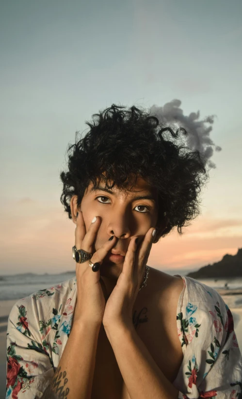 a woman smoking a cigarette on the beach, an album cover, inspired by Byron Galvez, pexels, vanitas, curls on top of his head, androgynous male, early morning lighting, mexican