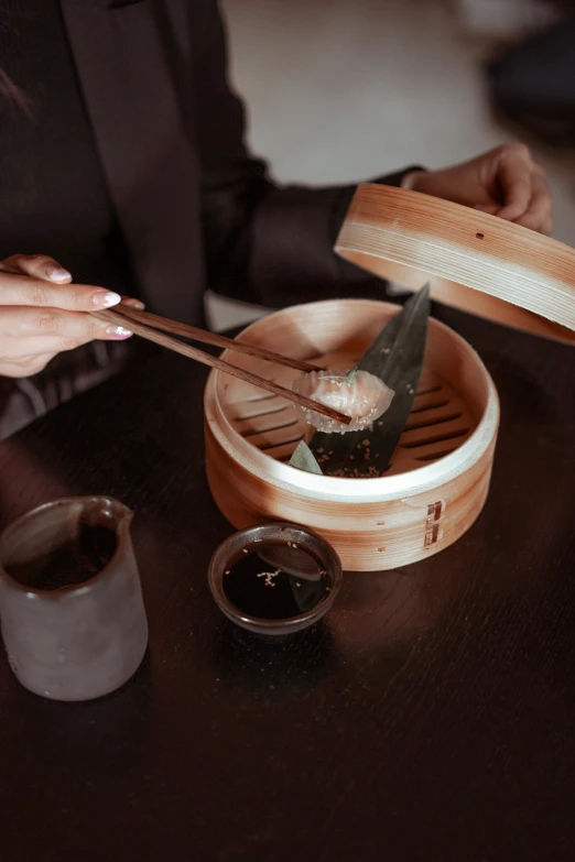 a woman sitting at a table with a dim dim dim dim dim dim dim dim dim dim dim dim dim dim dim dim dim dim dim dim, a picture, inspired by Feng Zhu, trending on unsplash, steamed buns, on a wooden tray, but futuristic food, medium close up