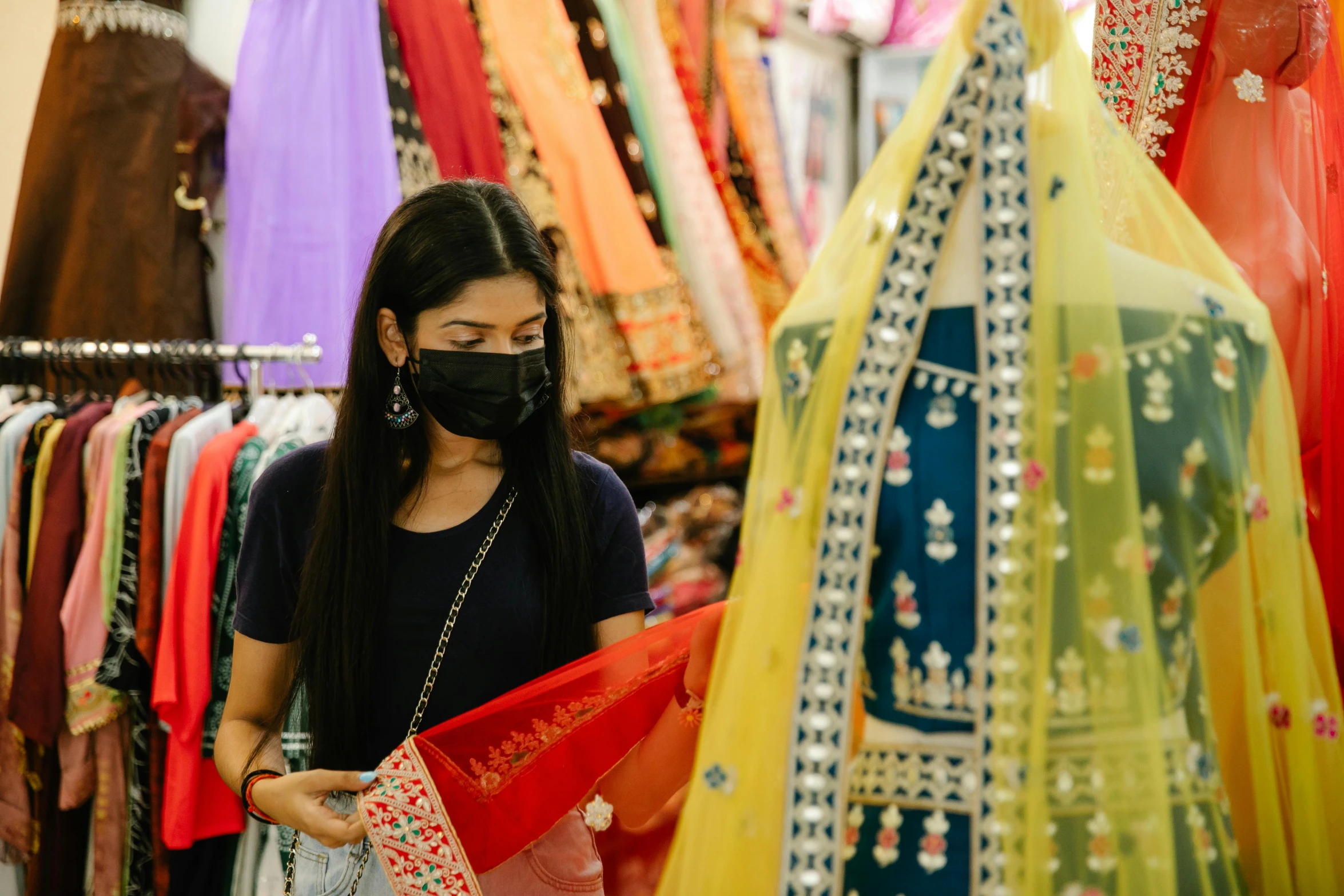 a woman wearing a face mask in a store, trending on pexels, hurufiyya, dressed in a sari, charts, south east asian with long, a person at a music festival