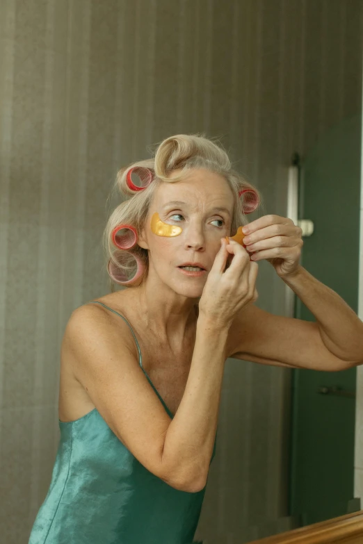 a woman with curlers on her face in front of a mirror, inspired by Cindy Sherman, old gray hair, bags under eyes, skincare, square