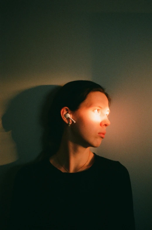 a woman standing in front of a white wall, an album cover, unsplash, bauhaus, police lights shine on her face, aphex twin, headshot profile picture, andrea savchenko