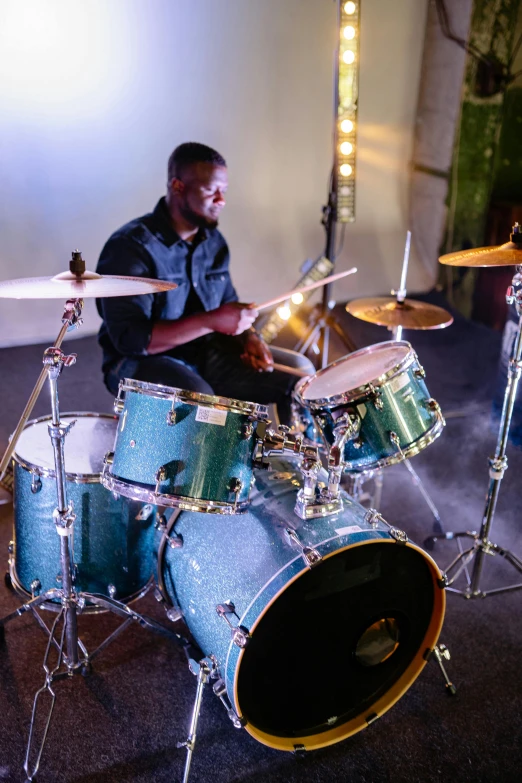 a man sitting in front of a drum set, profile image