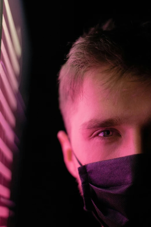 a close up of a person wearing a face mask, by Adam Marczyński, young man in a purple hoodie, glowing from inside, andrew dickson, curious