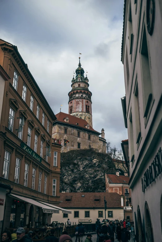 a group of people walking down a street next to tall buildings, a picture, pexels contest winner, baroque, in legnica, neoclassical tower with dome, built on a steep hill, stacked image