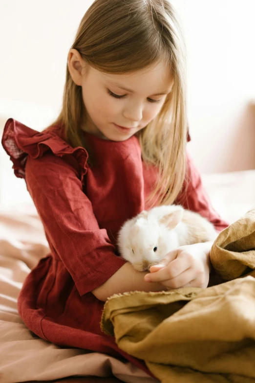 a little girl sitting on a bed holding a hamster, inspired by Elsa Beskow, white rabbit, hugs, full product shot, brown