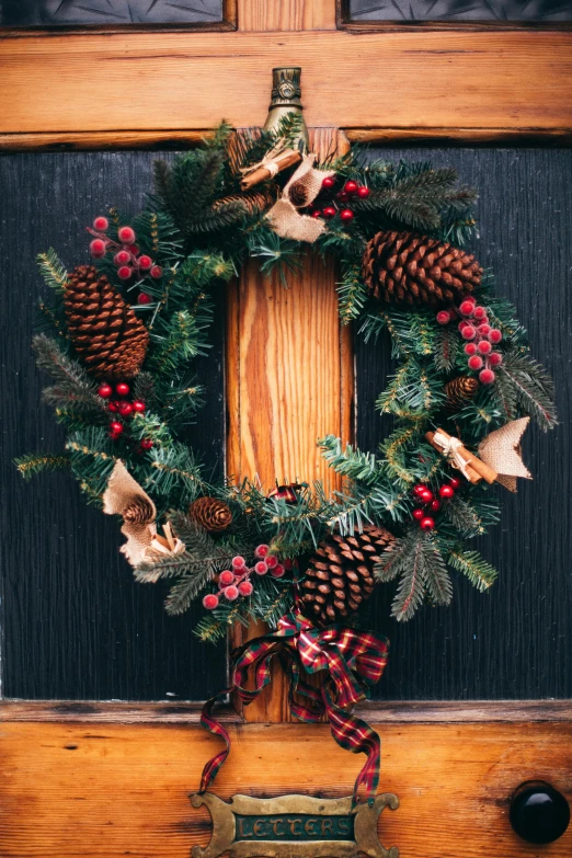 a close up of a wreath on a door, a digital rendering, pexels, pinecone, fully decorated, rustic, maroon