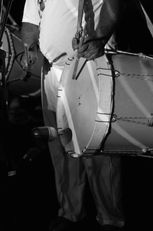 a black and white photo of a man holding a drum, by Maurycy Gottlieb, detail shots, ( ( photograph ) ), concert, salvador